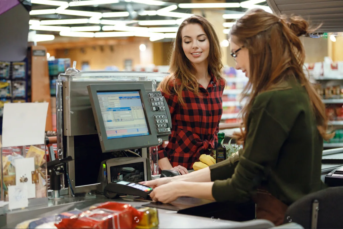 A customer at a supermarket self-checkout lane.