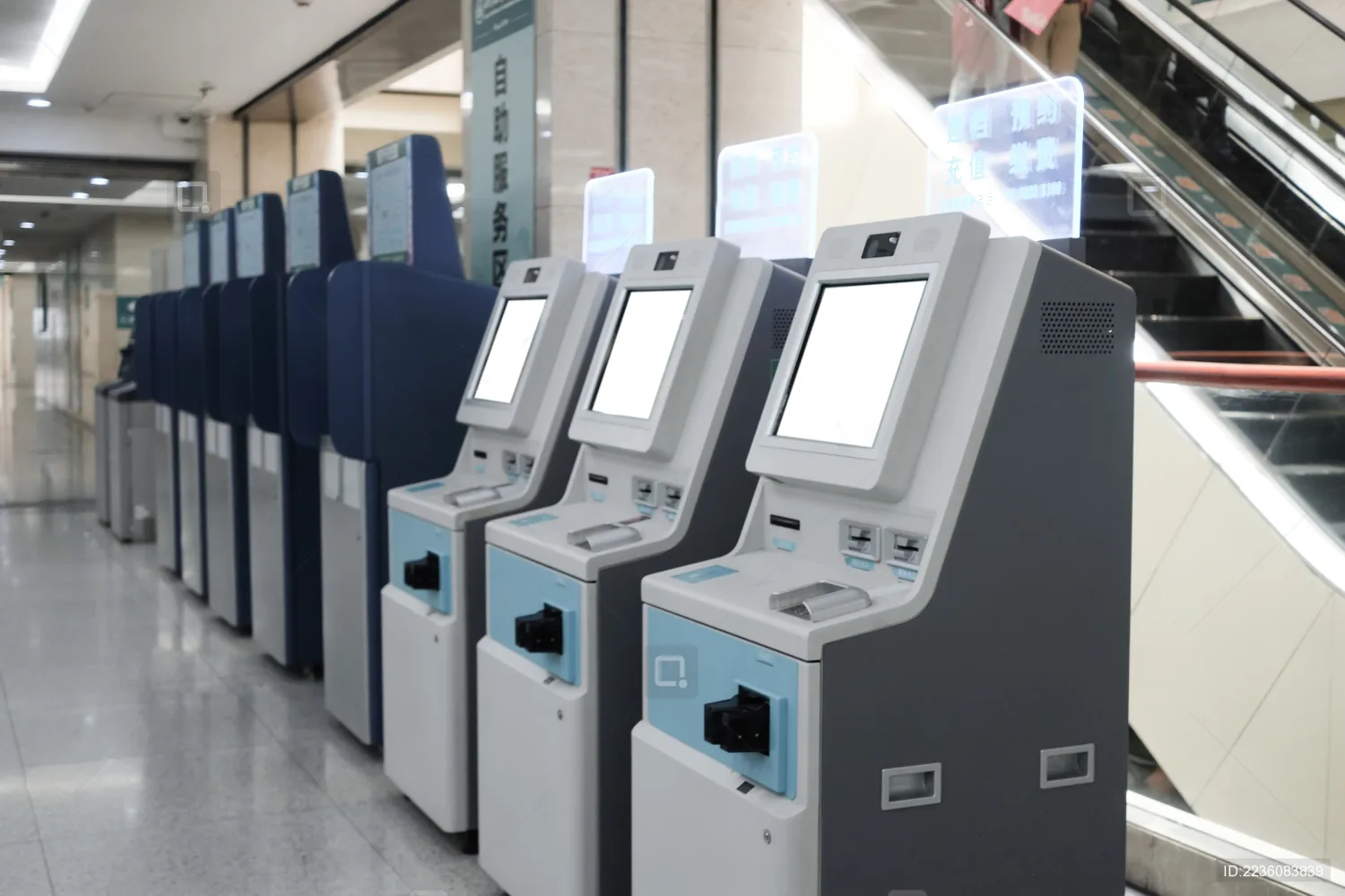 A row of self-service banking terminals along a branch concourse.